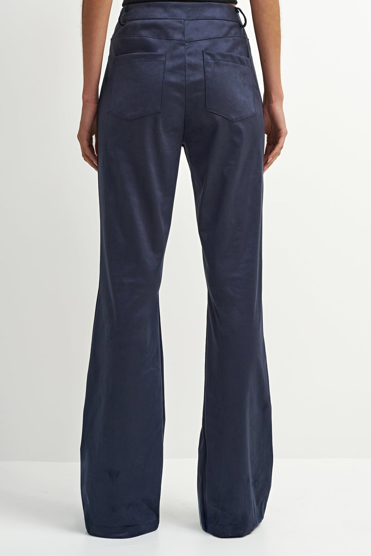 Rear view of a model wearing navy blue wide-leg trousers against a plain white studio background.