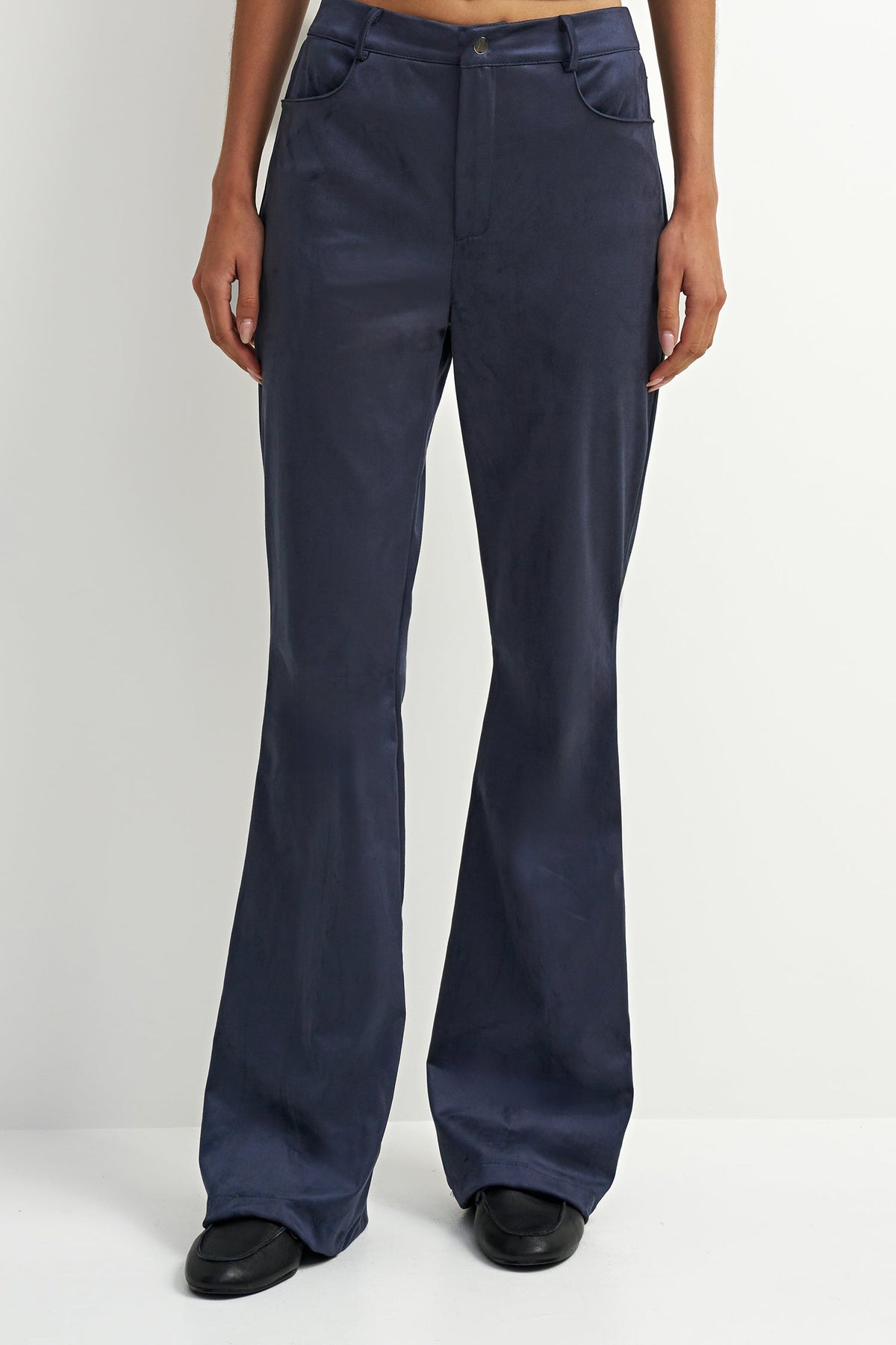 A person wearing dark navy wide-leg pants with black shoes, shown from the waist down against a plain light gray studio background.