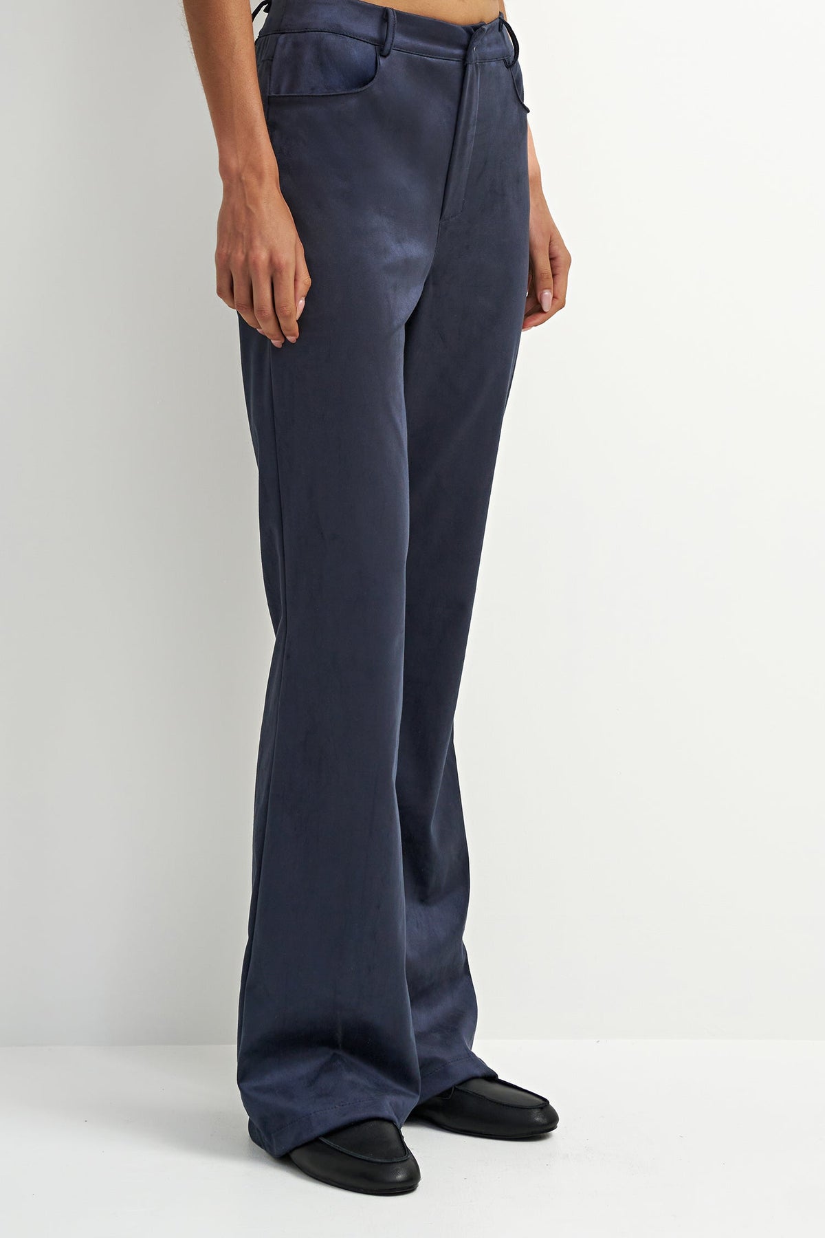 A model wearing a pair of dark navy blue wide-leg trousers with black shoes, shown from the waist down against a plain white studio background.