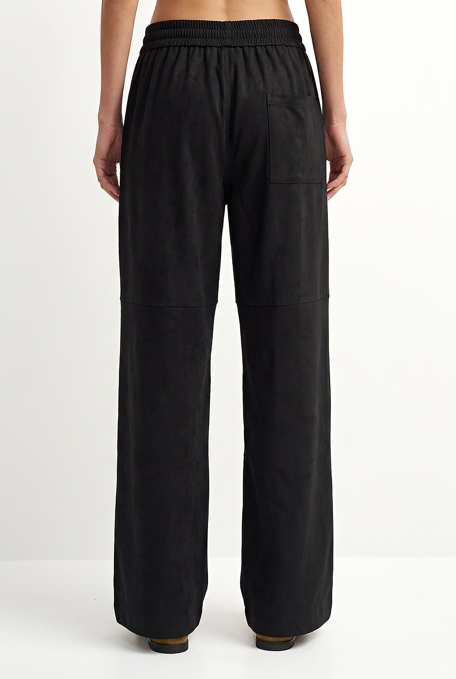 Black wide-leg trousers with an elastic waistband and a side pocket, shown from the back on a model against a white studio background.