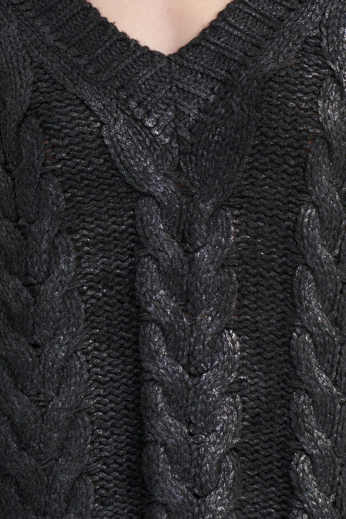 Close-up of a black cable-knit sweater with a V-neck, showing detailed knit texture and braided patterns.